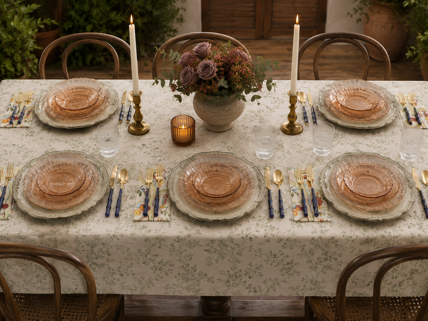 Light green floral tablecloth layered with simple glassware and white china